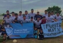 Belgrano de Río Primero debutó con un triunfo en el Torneo Permanencia Jugadores de Belgrano de Río Primero posan junto a niños con banderas del club en una cancha de fútbol