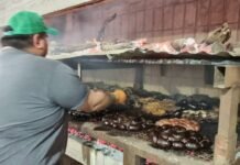 Media Luna Sud fue sede de la primera edición del Festival del Costillar Persona trabajando frente a una parrilla con carne y embutidos sobre las brasas durante el Festival del Costillar