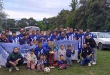 Sol de Mayo de Piquillín gritó campeón en la Zona Plata Jugadores, familias y niños posan junto a la bandera de Sol de Mayo, el trofeo y una pelota de fútbol