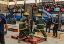 Bomberos de Monte Cristo participaron de la Copa Bomberil en Alta Gracia Dos bomberos equipados realizan una prueba con una estructura pesada dentro de un gimnasio