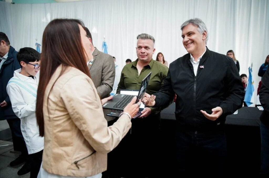 Durante un acto institucional se entrega una computadora portátil con la presencia de Martín Llaryora