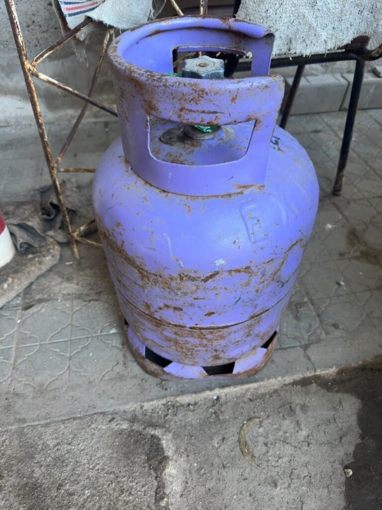 Garrafa de gas de 10 kilogramos apoyada sobre una vereda